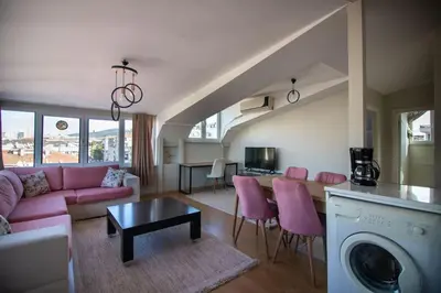 a living room with a pink couch and a table at Charming 2BR Panoramic Views Penthouse in Maltepe in Istanbul