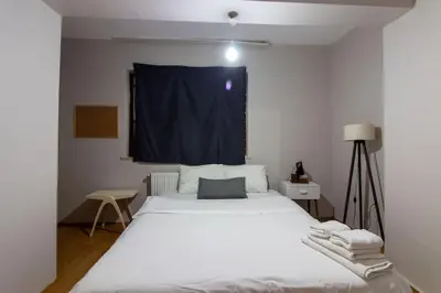 a bedroom with a large white bed with a blue curtain at Cozy Modern 1BR w Patio New Building in Maltepe in Istanbul