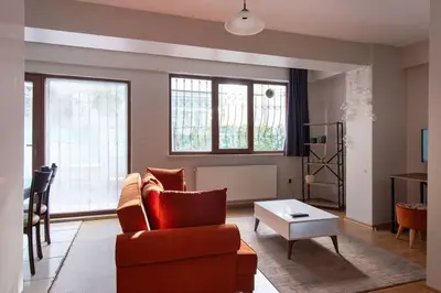 a living room with a couch and a table at Cozy Modern 1BR w Patio New Building in Maltepe in Istanbul
