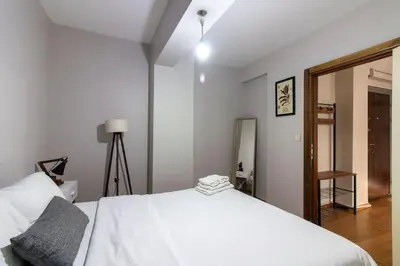 a bedroom with a white bed and a mirror at Cozy Modern 1BR w Patio New Building in Maltepe in Istanbul