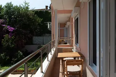 a balcony with a wooden table and chairs on it at Designed and Modern 2BR Flat In Center Of Buyukada in Adalar