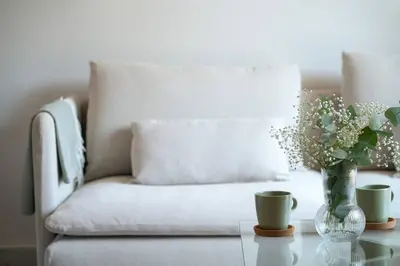 a living room with a couch and a vase of flowers on a table at Designed and Modern 2BR Flat In Center Of Buyukada in Adalar