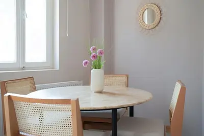 a dining room table with a vase of flowers on it at Designed and Modern 2BR Flat In Center Of Buyukada in Adalar