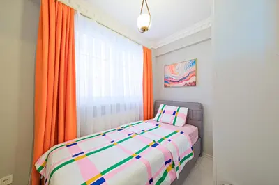 a bedroom with a bed and an orange curtain at Taksim İstiklalin Kalbinde Konforlu Daire Netflix Wifi in Istanbul