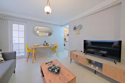a living room with a large television and a table at Taksim İstiklalin Kalbinde Konforlu Daire Netflix Wifi in Istanbul