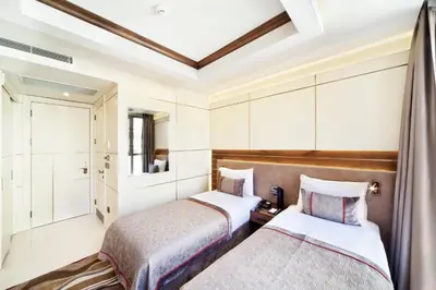 two beds in a hotel room with a window at Grand Hotel de Pera in Istanbul