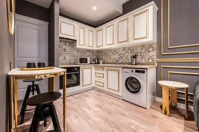 a kitchen with white cabinets and a washer and dryer at Grand Hotel de Pera in Istanbul
