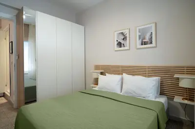 a bedroom with a green bed with white pillows at Bright and Cozy 2BR Apt In The Center Of Buyukada in Adalar