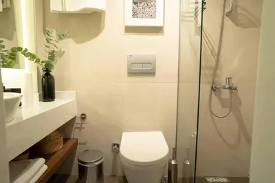 a bathroom with a toilet and a glass shower at 2BR Designed Flat In The Center of Buyukada in Adalar