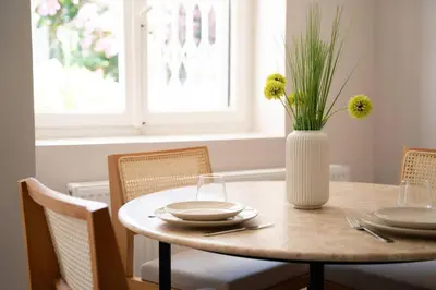 a dining room table with a vase with flowers on it at 2BR Designed Flat In The Center of Buyukada in Adalar