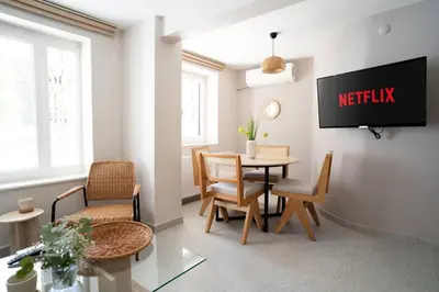 a living room with a table and chairs and a tv at 2BR Designed Flat In The Center of Buyukada in Adalar