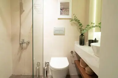 a bathroom with a toilet and a glass shower at Modern and Designed 2BR W Garden in Adalar