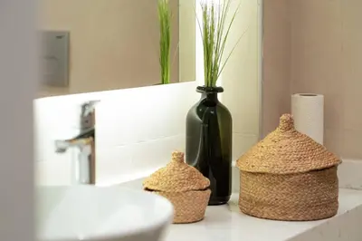 a bathroom counter with a black vase and two baskets at Modern and Designed 2BR W Garden in Adalar