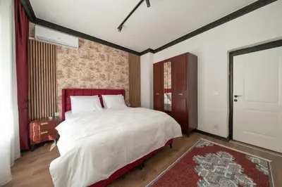 a bedroom with a large white bed with a red headboard at Hexa Apartments Sisli in Istanbul
