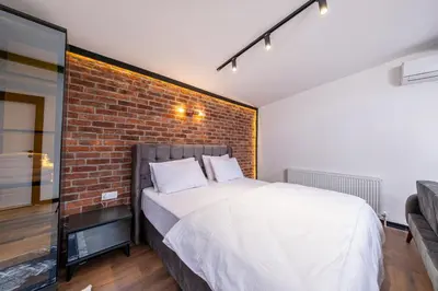 a bed in a room with a brick wall at Hexa Apartments Sisli in Istanbul