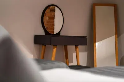 a mirror sitting on a stand next to a bed at Spacious and Stylish 3BR w Private Garden in Istanbul