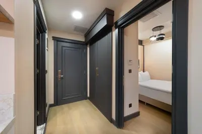 a hallway with black doors and a bed in a room at Şişli Family Time Suites in Istanbul