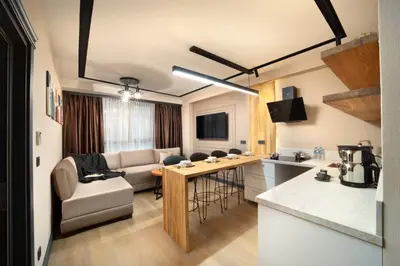 a kitchen and living room with a couch and a table at Şişli Family Time Suites in Istanbul