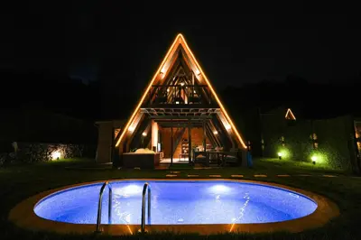 a house with a swimming pool at night at Happy Enjoy Bungalow in Sapanca