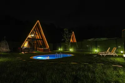 a backyard at night with a swimming pool at Happy Enjoy Bungalow in Sapanca