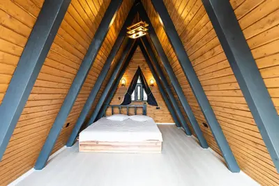 a bed in a room with wooden walls and a ceiling at Happy Enjoy Bungalow in Sapanca