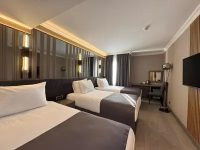 a hotel room with two beds and a couch at Aven Hotel in Istanbul