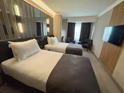 a hotel room with two beds and a television at Aven Hotel in Istanbul