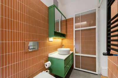 a bathroom with a green sink and orange tiles at Liberty Residence in Istanbul