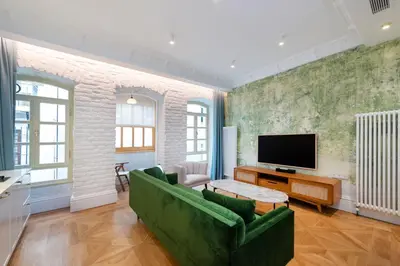 a living room with a green couch and a tv at Liberty Residence in Istanbul