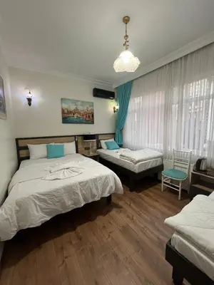 a bedroom with two beds and a chair in it at Sultanahmet Sefa Hotel in Istanbul