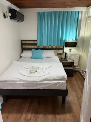 a bed in a bedroom with a blue curtain at Sultanahmet Sefa Hotel in Istanbul