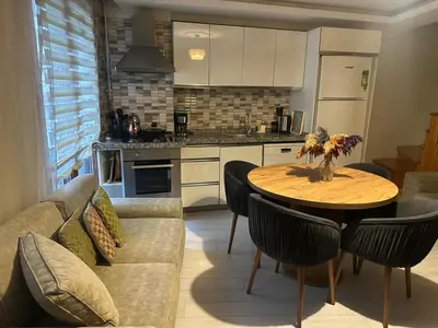 a kitchen and living room with a table and a couch at Modern Suites Galata in Istanbul