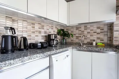a kitchen with white cabinets and a sink at Modern Suites Galata in Istanbul