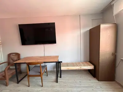a dining room with a table and a tv on a wall at i1 House Hotel in Istanbul