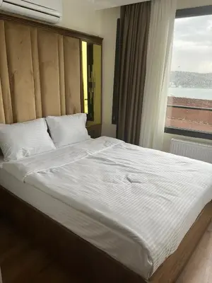 a large bed in a bedroom with a window at Lokka Hotel Ortakoy in Istanbul