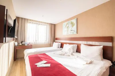 a hotel room with two beds and a red blanket at Park by Clover Nişantaşı Harbiye Şişli in Istanbul