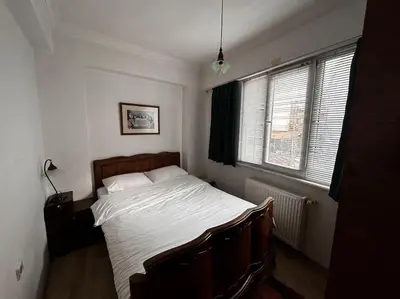 a bedroom with a bed with white sheets and two windows at Cozy Flat to Taxim, Beyoglu, Pera, Galata in Istanbul