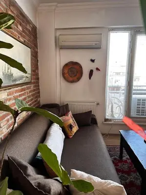 a living room with a couch and a brick wall at Cozy Flat to Taxim, Beyoglu, Pera, Galata in Istanbul