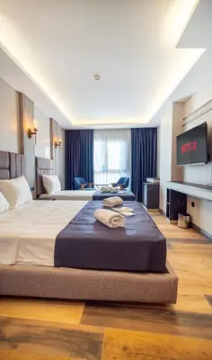 a hotel room with two beds and a tv at Modernlux Hotel in Istanbul