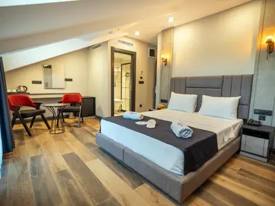 a bedroom with a bed and a table and chairs at Modernlux Hotel in Istanbul