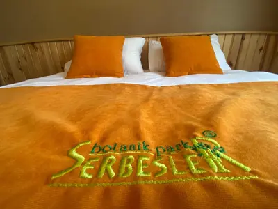 a bed with an orange blanket on top of it at Serbesler Botanik, No 2 Mini House in Sakarya
