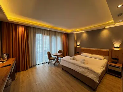 a bedroom with a large bed and a table in it at Enjoy Suit in Tuzla