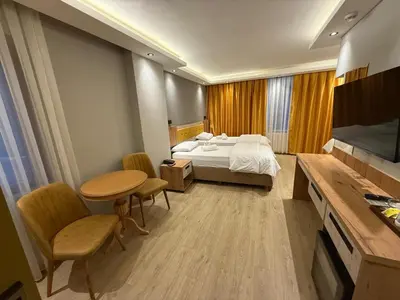 a bedroom with a bed and a table and chairs at Enjoy Suit in Tuzla