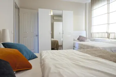 a white bedroom with two beds and a window at Spacious Balcony Suite Sultanahmet - Aslan Apartments in Istanbul
