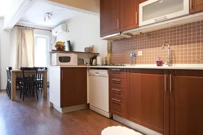 a kitchen with wooden cabinets and a table with chairs at Spacious Balcony Suite Sultanahmet - Aslan Apartments in Istanbul