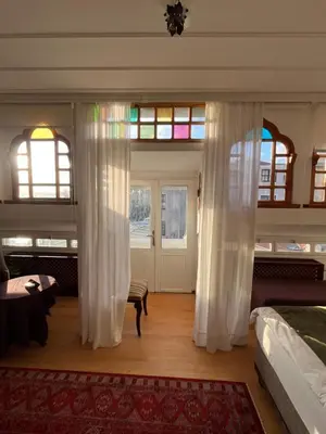 a bedroom with white curtains and a room with a door at Levant Pension de Luxe in Istanbul