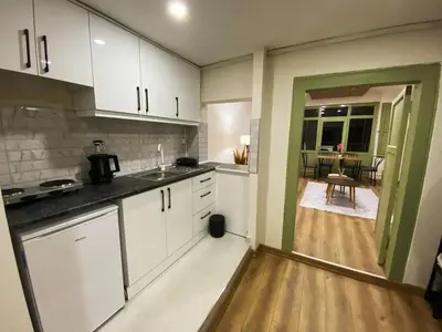a kitchen with white cabinets and a dining room at Özkanlar in Istanbul