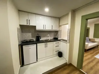 a kitchen with white cabinets and a sink and a couch at Özkanlar in Istanbul