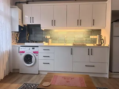 a kitchen with white cabinets and a washing machine at Evinizin Konforunu Yaşayın ! in Istanbul