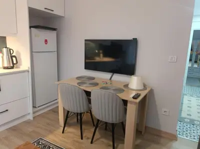 a kitchen with a table with two chairs and a refrigerator at Evinizin Konforunu Yaşayın ! in Istanbul